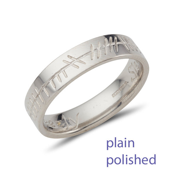 white gold easy it wedding band with a plain polished and curved inside,  it has an Ogham inscription on the outside of the band