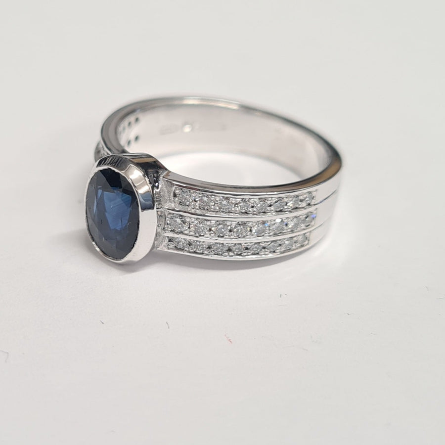 18ct-white-gold-sapphire-and-diamond-ring-with-bezel-set-oval-sapphire-and 3 rows-of-channel-set-diamonds