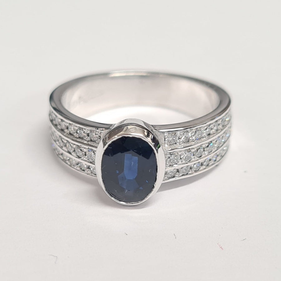 18ct-white-gold-sapphire-and-diamond-ring-with-bezel-set-oval-sapphire-and 3 rows-of-channel-set-diamonds