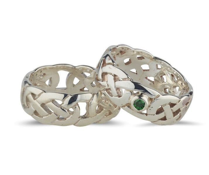 sterling silver celtic design rings with a fully pierced out celtic pattern, ideal for both male an female, they are 7.5mm wide one ring is set in the centre with a bezel set green cubic zirconia, the other ring has no stone