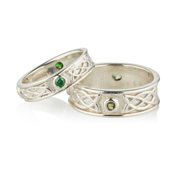 wite gold celtic design matching his and hers rings, they are set with 3 emeralds in each ring, the 3 stones are rubover or bezel set at north east and west points of the ring