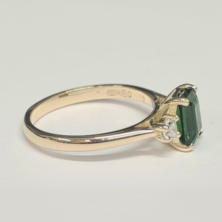 18ct yellow gold 3 stone ring. the ring has an emerald cut green tourmaline and lab created diamond all set in yellow gold