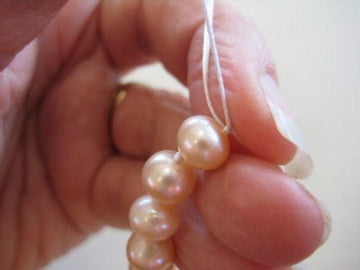 this picture shows someone restringing pearls