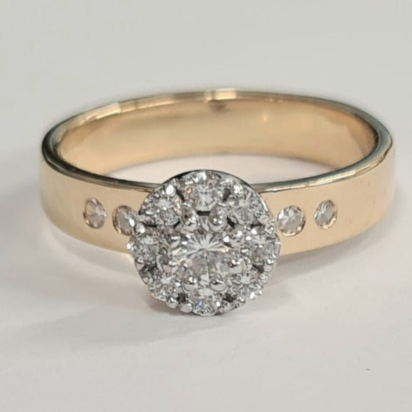 18ct halo cluster ring, the halo of diamonds is set in white gold, the halo is set onto a 4mm yellow gold band which has 4 bullet set diamonds in it