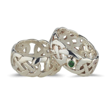this picture shows 2 rings both sterling silver celtic design rings with a fully pierced out celtic pattern, ideal for both male an female, they are 7.5mm wide, ont of them is plain the other is bezel set with one green cubic zirconia stone