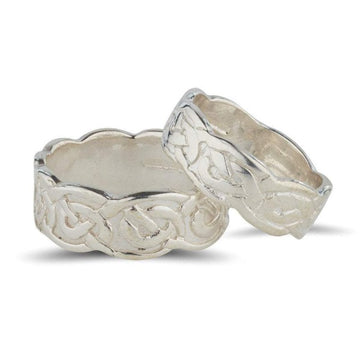 sterling silver celtic design matching his and hers rings, the pattern is embossed on the ring and the edges of the rings are wavy slightly wider