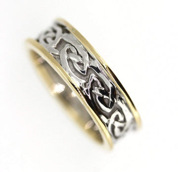 two tone celtic design ring with yellow gold rimms, the centre is silver celtic design pattern that is solid, the rimms are slightly raised