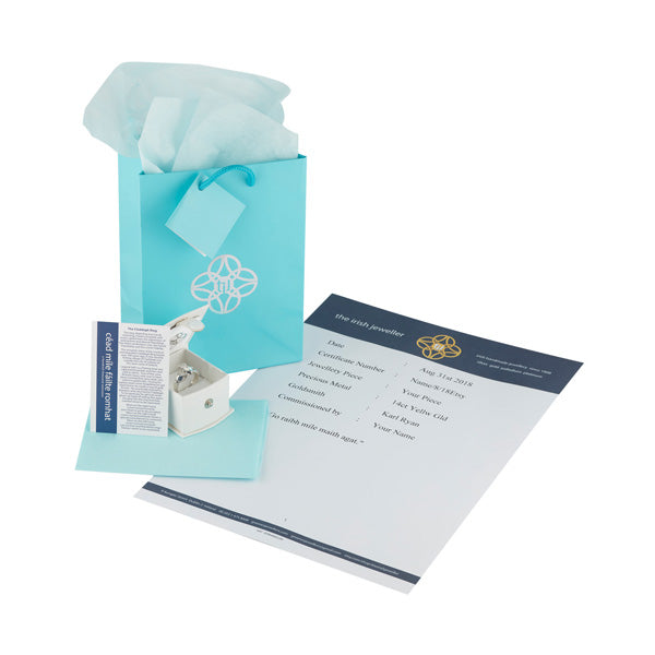 this shows the presentation a gift bag a card explaining the story of the claddagh design and a bag with matching tissue,  all turquoise blue