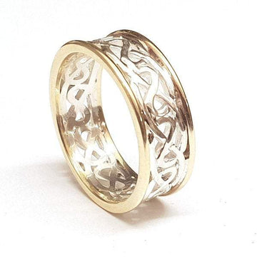 two tone celtic design ring with yellow gold rimms, the centre is silver celtic design pattern that is pierced out, the rimms are slightly raised