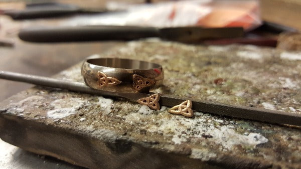 white gold d shape wedding ring before the yellow gold trinity knots get soldered onto the ring