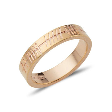 yellow gold flat plain polished wedding ring that is engraved with ogham script